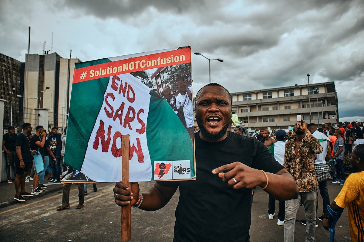Port Harcourt, Nigeria - October 20, 2020: A protester wielding a placard with "END SARS NOW" on it in the city of Port Harcourt in solidarity and as a sign for the #Endsars protests in Nigeria. Photo: Emmanuel Ikwuegbu/ Free to use under the Unsplash License