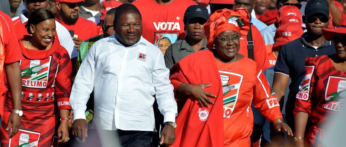 Mozambique president Filipe Nyusi and Frelimo party supporters smile.