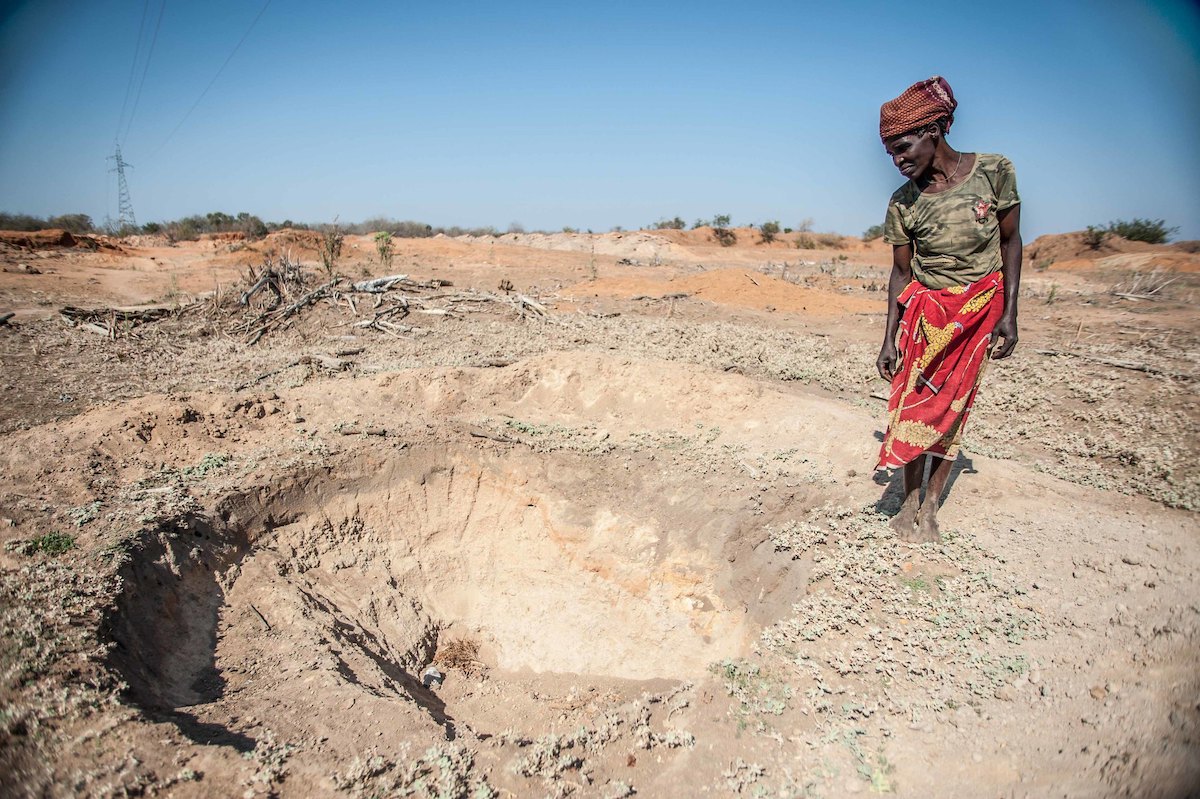 Adelaide Maphangane stands beside an empty water hole in the district of Mabalane, Mozambique.