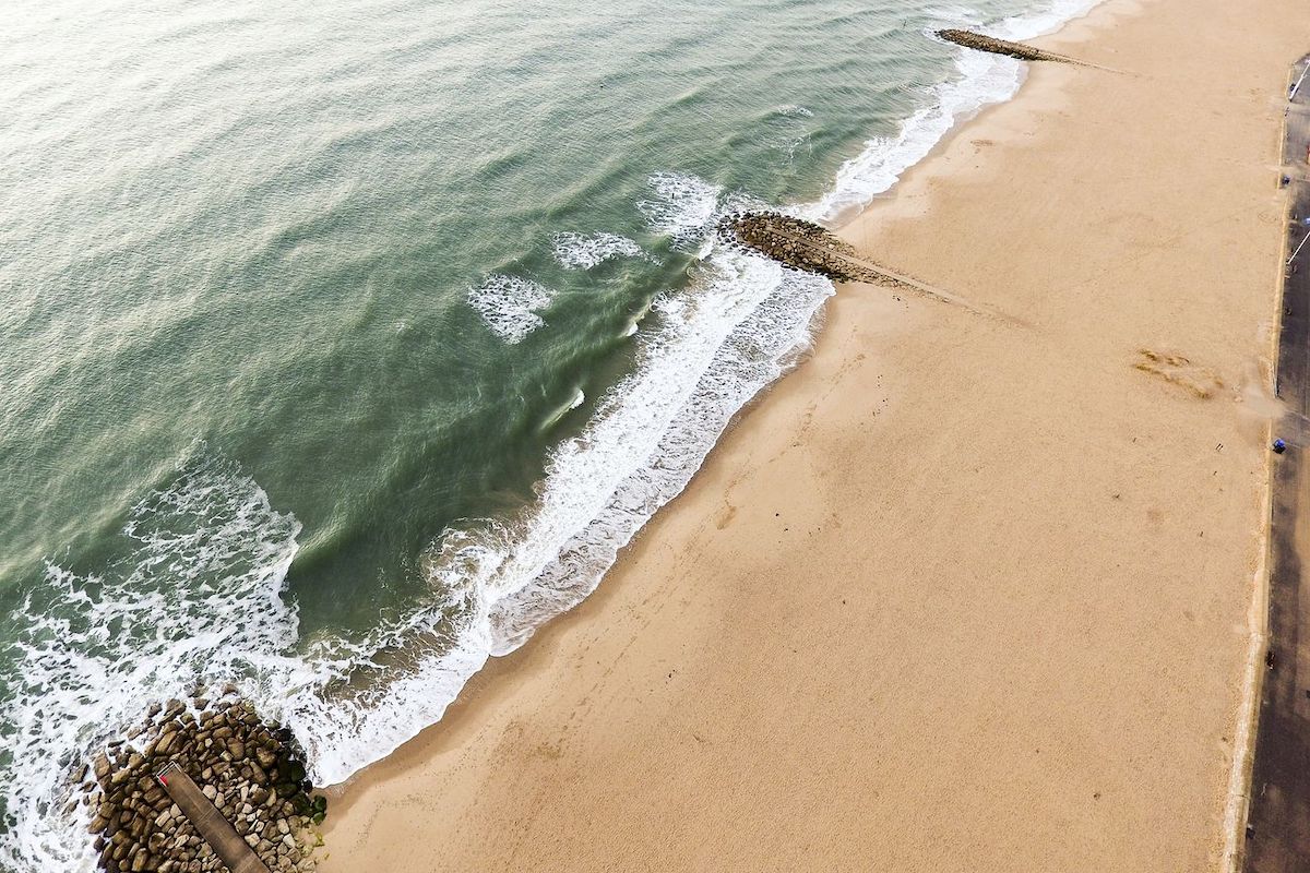 Small rock docks at the sand beach coastline