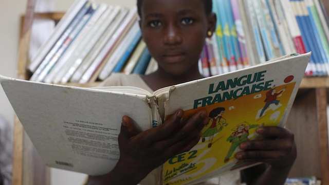 An African child holding a French book.