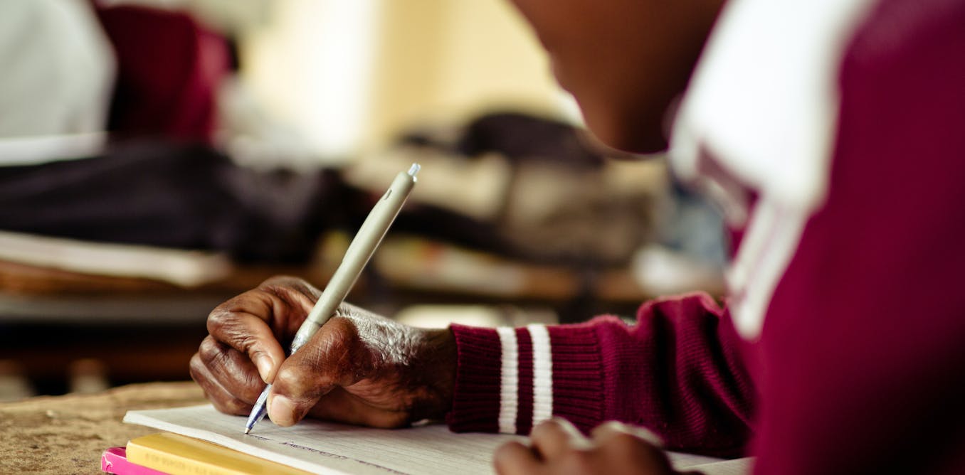 A school girl writing notes in her notebook.