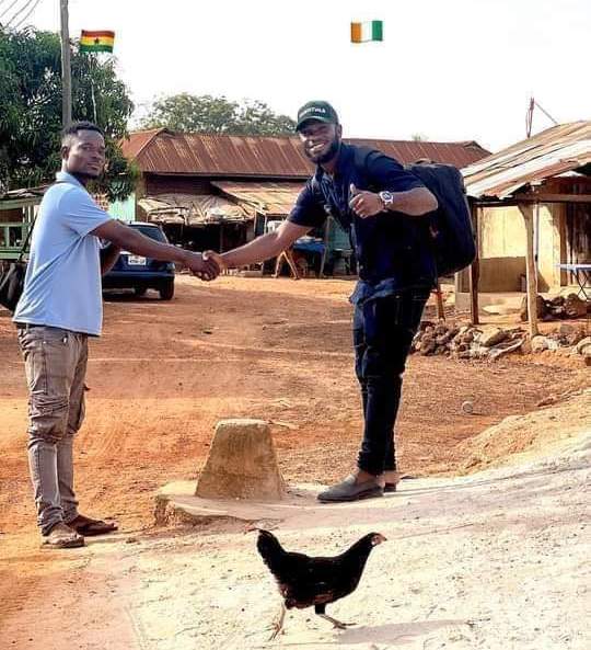 Two people shaking hands across Ghana/Cote D'Voire border