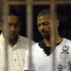 Policeman Shane Naidoo, left, leads Thabo Bester from holding cells in Durban.